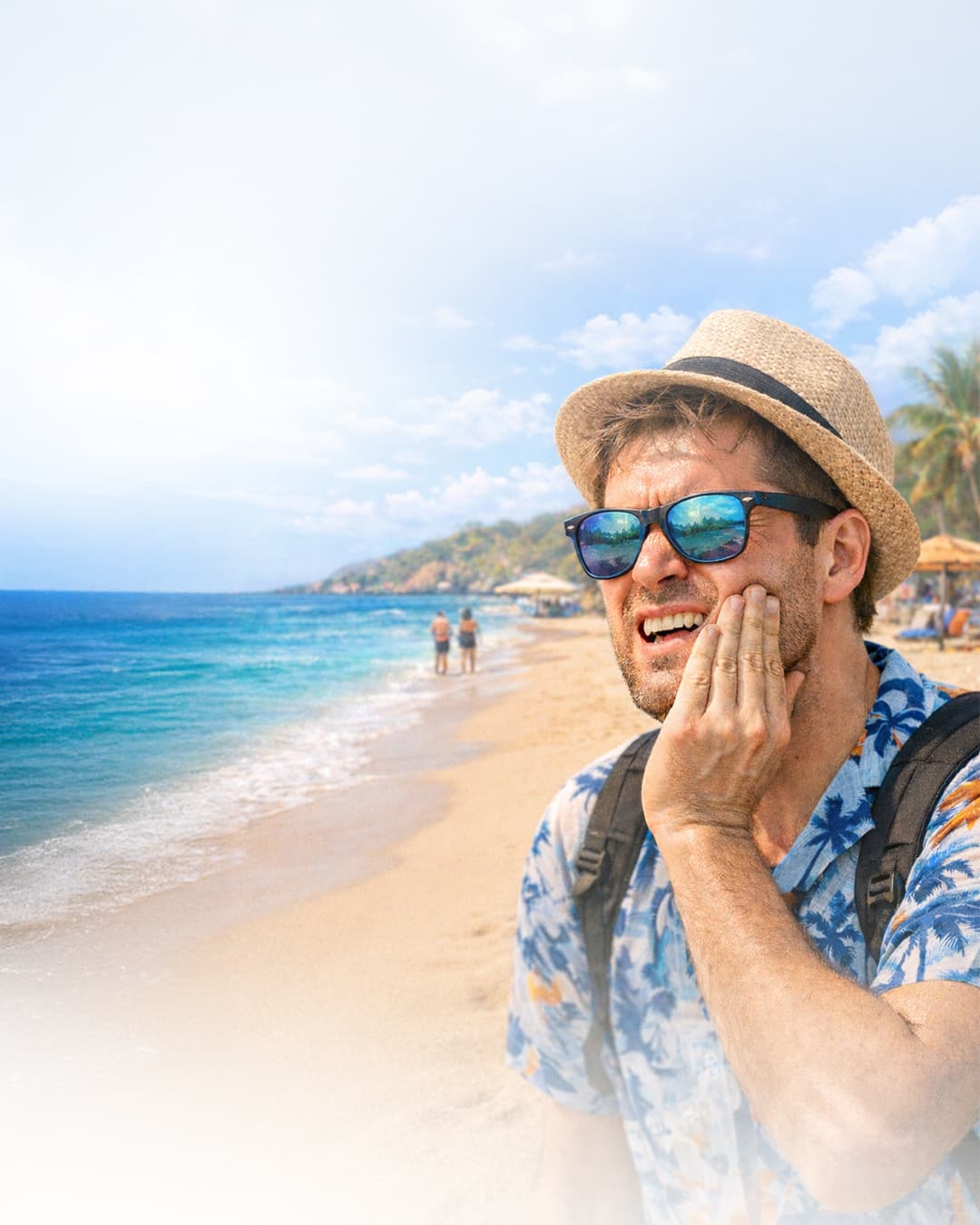 Tourist on a Marsa Alam beach holding his cheek in tooth pain