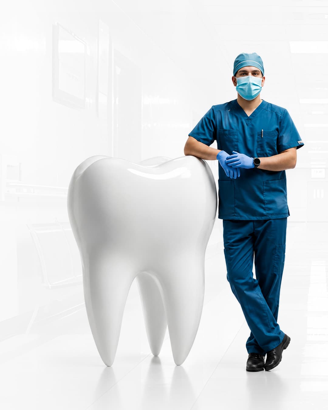 Dentist standing beside a large model tooth